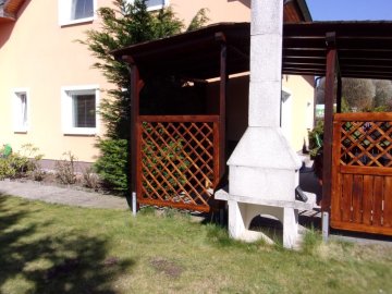 Zastřešenou pergolu si zákazník doplnil betonovým topeništěm s vysokým komínem Zastřešenou pergolu si zákazník doplnil betonovým topeništěm s vysokým komínem