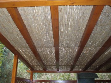 Na střešní krokve jsme nejprve připevnili přírodní rákos a na rákos položili čirý, 8 mm silný polykarbonát