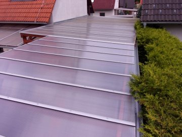 Pro zastřešení prodlouženého garážového stání jsme použili čirý komůrkový polykarbonát, který jsme na krokve připovnili přes hliníkové lišty