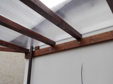 Pozednici opěrné pergoly jsme do zdi zahradního domku připevnili pomocí závitových tyčí a chemické malty