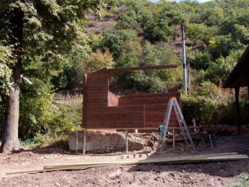 Montáž dřevěné chaty Kukka probíhla v upraveném terénu těsně pod příkrým svahem