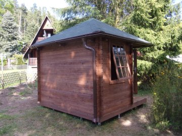 Prosklené výplně oken a dveří zahradního altánu jsou vyztuženy dřevěnými latěmi
