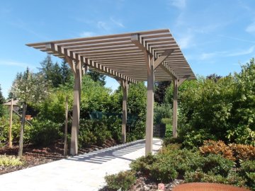 Nezastřešená pergola v šedém odstínu je moderním estetickým doplňkem zahrady
