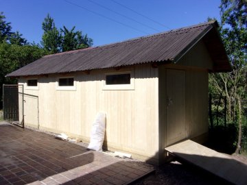 Dřevěné opláštění zahradní pergoly se sedlovou střechou doplněné o okna a dveře = zahradní domek na nářadí
