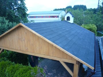 Komín zděného krbu prochází střechou zahradní pergoly
