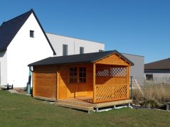Zahradní domek se sedlovou střechou jsme doplnili vysokou zástěnou a nízkou mříží
