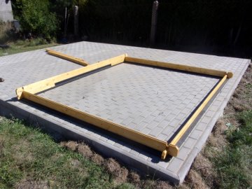 Zahradní dřevostavbu jsme smontovali na podkladu ze zámkové dlažby. Tvrdý plast byl základem pod chatu