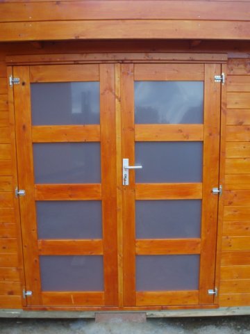 Dřevěný domek má dvoukřídlé prosklené dveře
